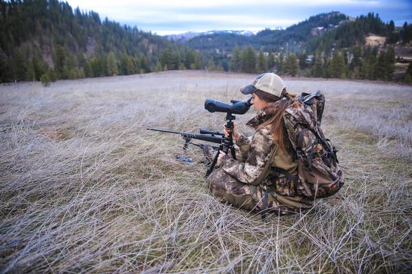 woman in camo looking through a spotting scope